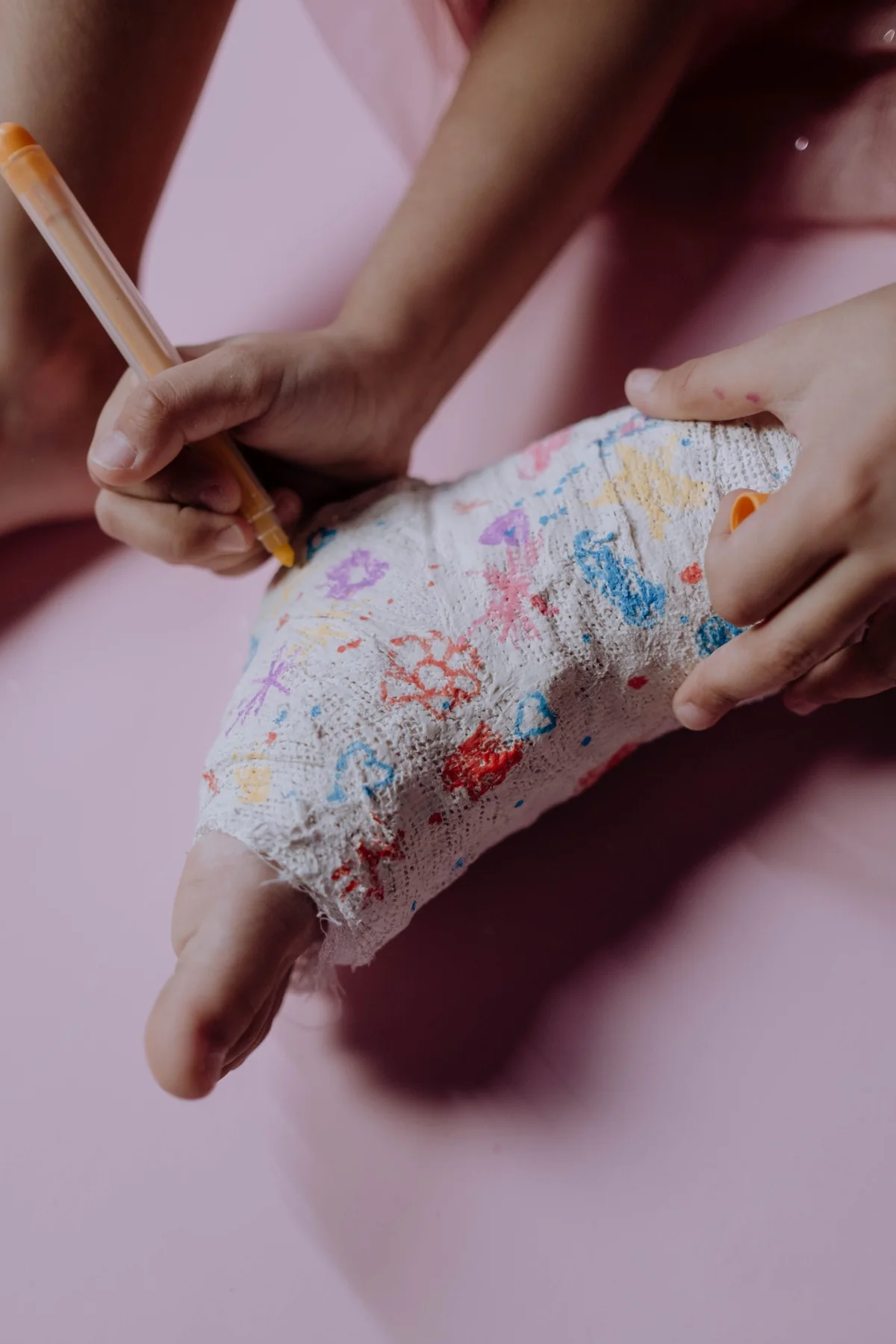 A child decorating a colourful cast