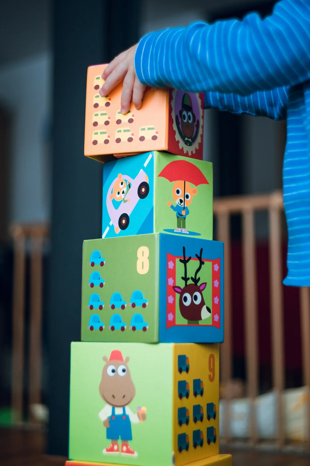 A child stacking colourful illustrated blocks