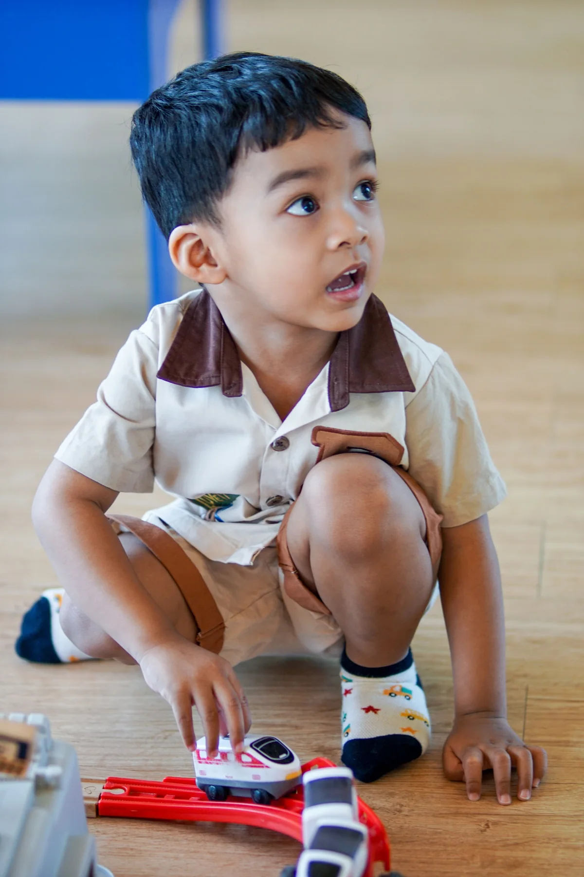 A young child playing with a toy train
