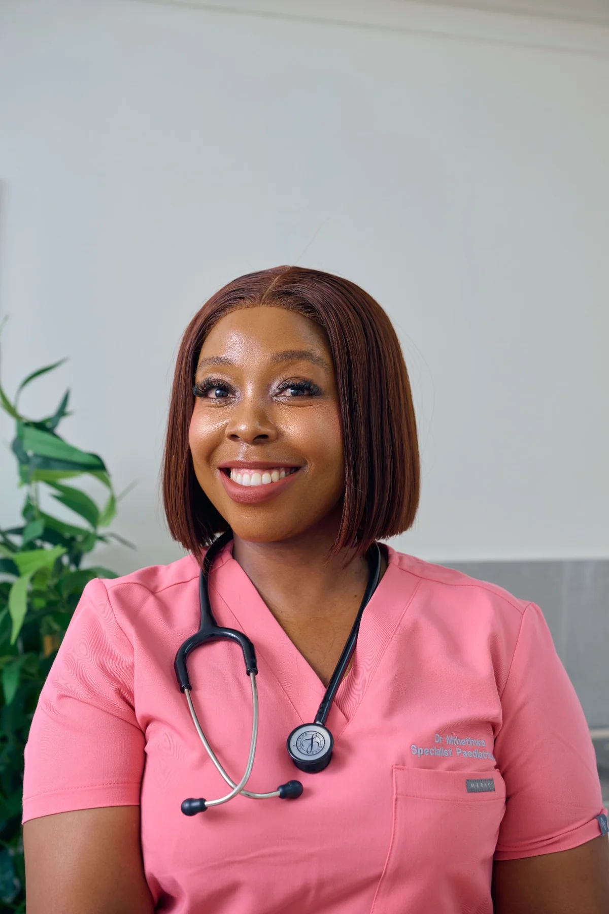 Portrait of Dr. Zinzi Mthethwa in pink scrubs with a stethoscope